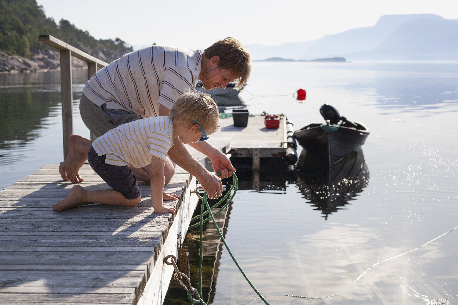 Far og sønn ved sjøen.